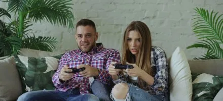 Young millennial guy and woman gaming together